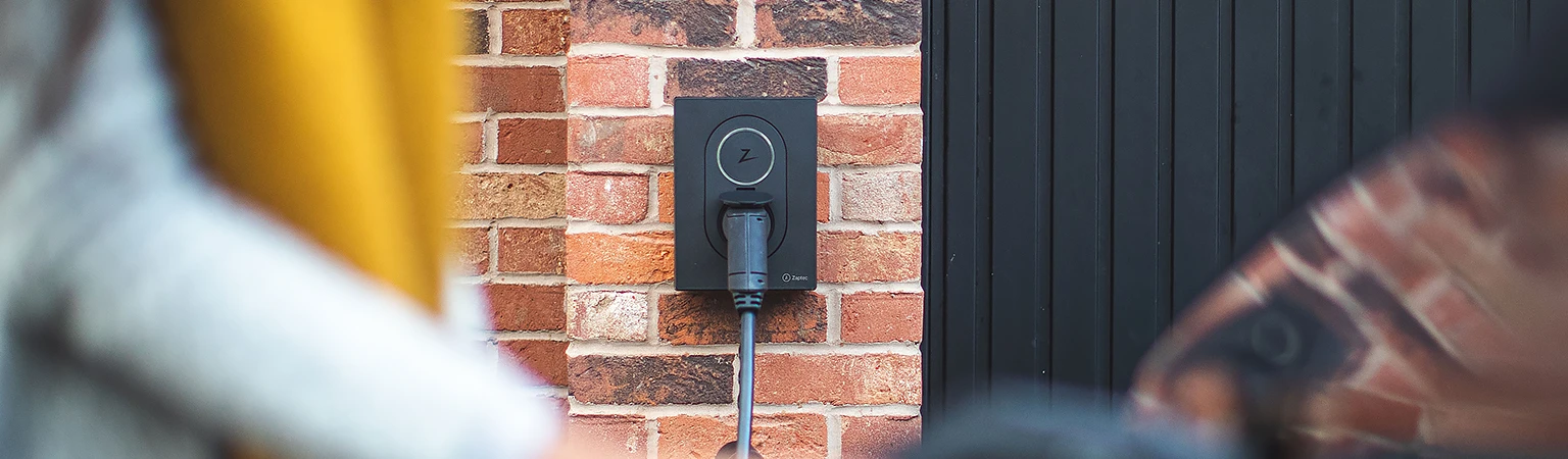 Zaptec Go -latausasema asennettuna omakotitalon tiiliseinään.